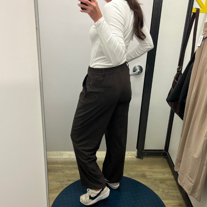 a woman wearing Old Navy High-Waisted SleekTech Trouser Pants against a natural background