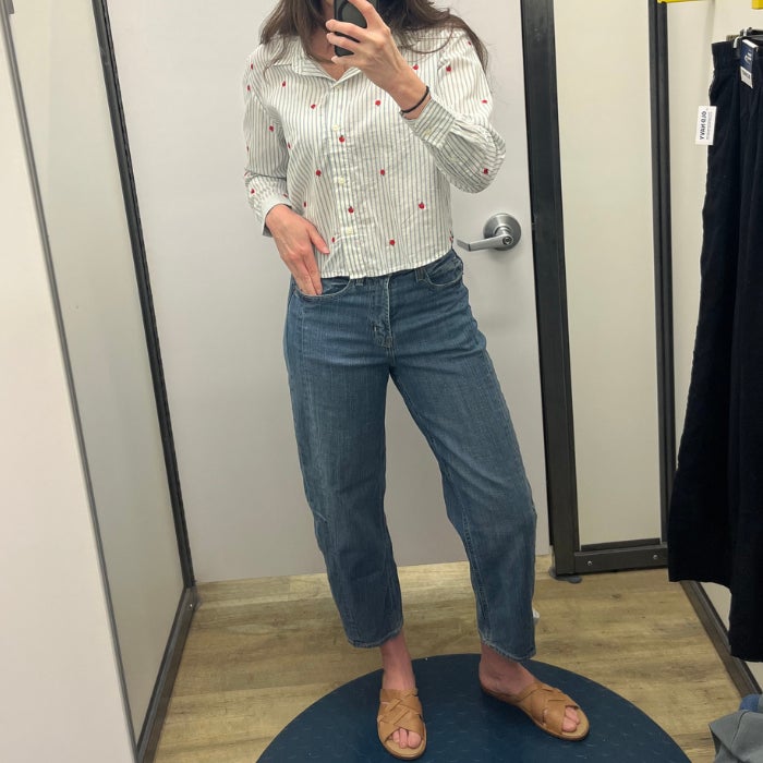 A woman wearing Old Navy High-Waisted Barrel Ankle Jeans against a natural background