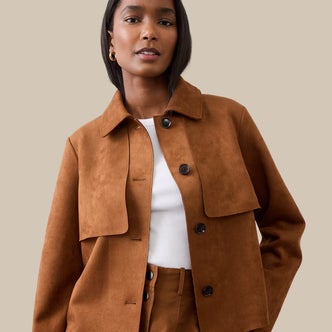 a woman wearing Banana Republic Factory Vegan Suede Short Trench against a beige background