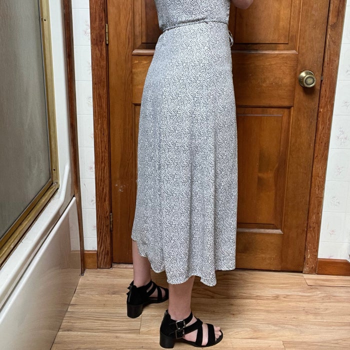 The lover half of a woman wearing Jockey Ultralight Smoothing Half Slip under a dress against a natural background