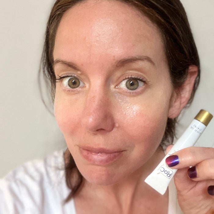 a woman's face after applying RoC Retinol Correxion Under Eye Cream against a beige background