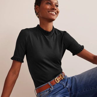 Boden; a woman wearing Boden Supersoft Frill Detail T-shirt against a beige background