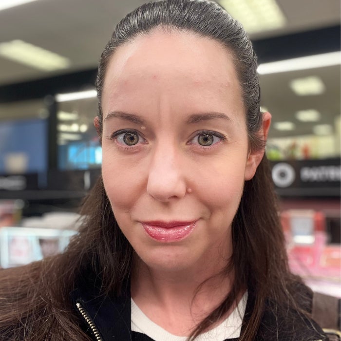 Brittany Brainard's face after applying LAWLESS Forget The Filler Lip Plumper Line Smoothing Gloss against a natural background