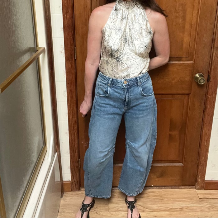 A woman wearing Kut From The Kloth Ashlyn Barrel Jeans against a natural background