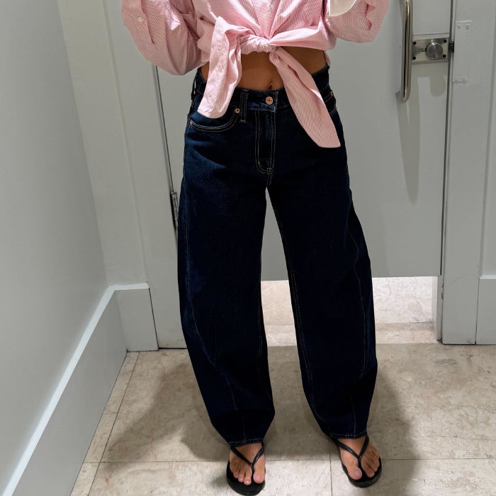 Anastasia Bilzhause wearing dark wash Gap High Rise Barrel Jeans in a white dressing room