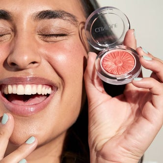 Ulta Beauty; A woman holding a compact of Clinique Cheek Pop Powder Blush against a neutral background