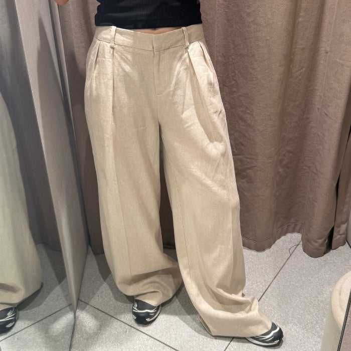 The front view of the bottom half of a woman wearing Zara Wide Leg Linen Pants against a natural background