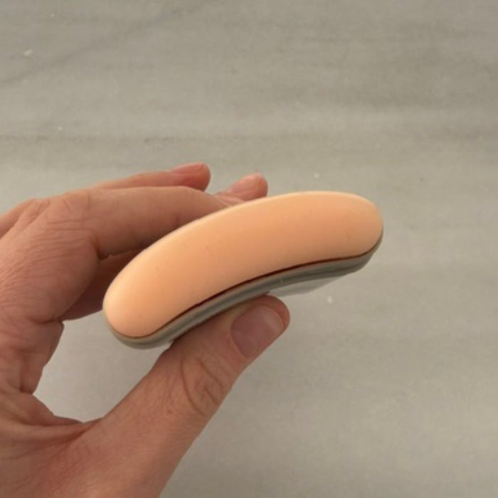 Tester Allison Wall holding Abib Airy Sunstick Smoothing Bar SPF 50+ in her hand to show the curved product shape against a neutral background