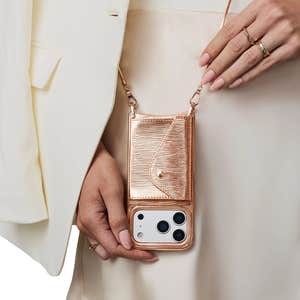 Bandolier; Gia Embossed Metallic Vegan Leather Crossbody Phone Case in Rose Gold Wave against a natural background