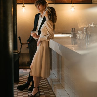 A man and a woman leaning against a counter in a restaurant