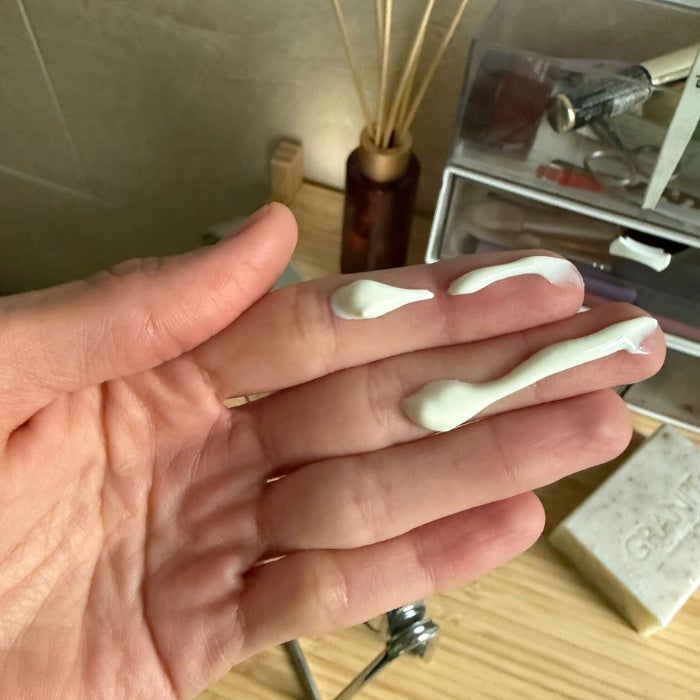 Tester Anastasia Bilzhause's hand with a line of Beauty of Joseon Day Dew Sunscreen down two fingers against a natural background