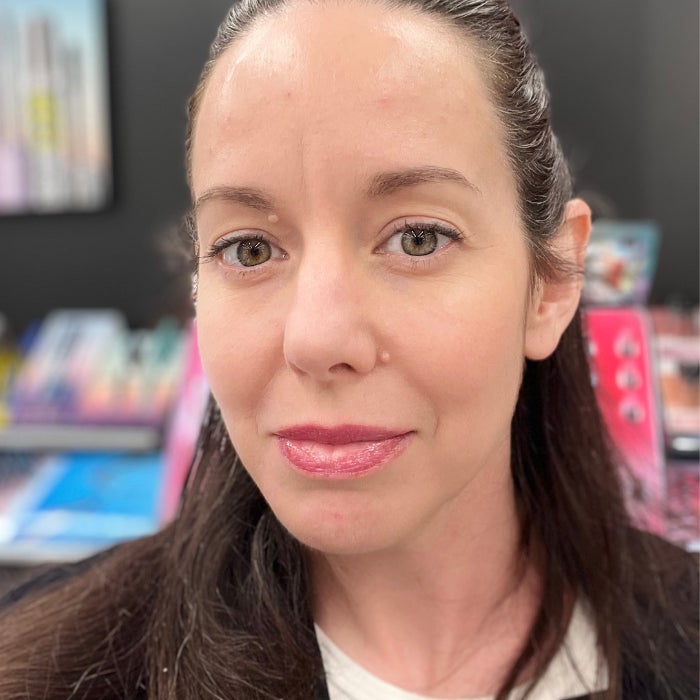 Brittany Brainard's face after applying Kosas Wet Lip Oil Gloss against a natural background