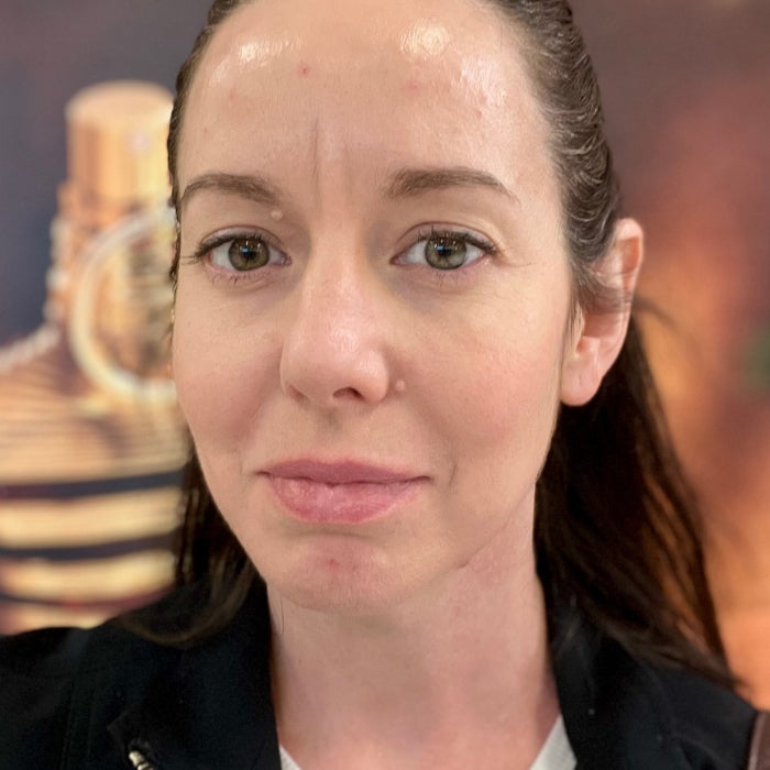 Brittany Brainard's face before applying Kosas Wet Lip Oil Gloss against a natural background