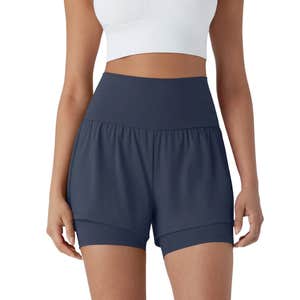 A person wearing dark blue Halara SoftlyZero™ Airy Super High Waisted Yoga Shorts and a white top against a white background