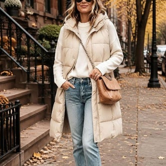 Amazon; a woman wearing Tanming Women's Long Puffer Vest with Removable Hood against a natural outdoor background