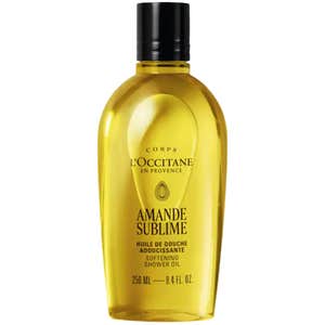 gold l'occitane cleansing and softening shower oil bottle on white background