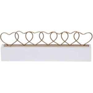 gold metal heart card holder with white base on white background