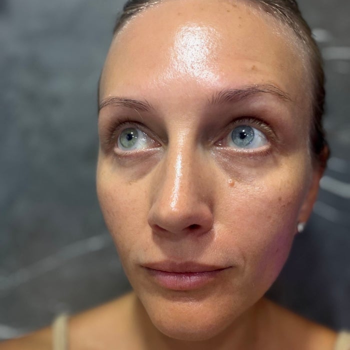 A woman's face after applying Clarins Double Serum against a natural background