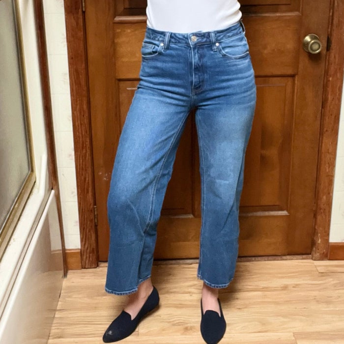 A front view of a woman wearing Bella Stretch Relaxed Straight Jeans against a natural background